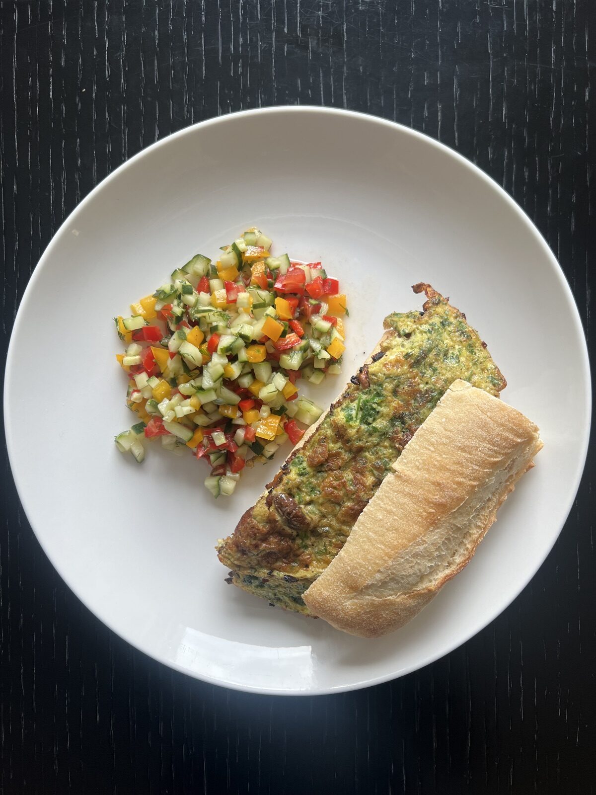 A protein-rich meal with a herb omelet sandwich and fresh vegetable salad
